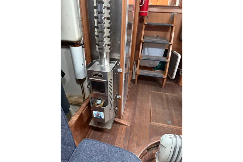 Slide: The Image of Compact wood stove in a 1990 HMMD 46 boat interior, featuring wooden flooring and ladder. - 10