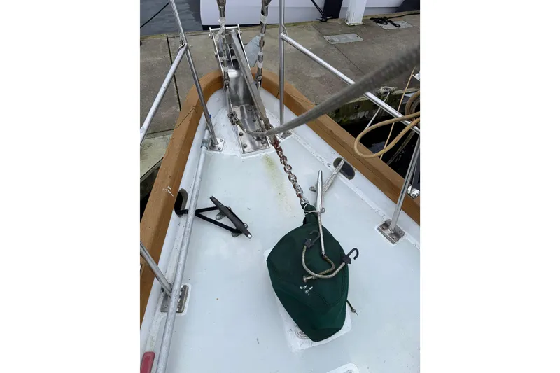 Slide: The Image of Bow of 1990 HMMD 46 sailboat with anchor chain and green cover. - 7