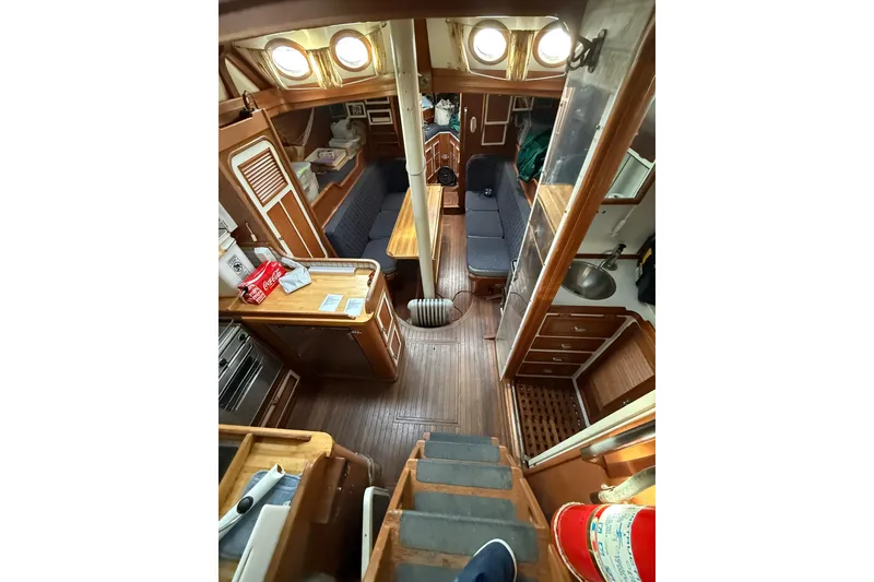 Slide: The Image of Interior of a 1990 Custom 46 sailboat with wooden furnishings and cozy seating area. - 17