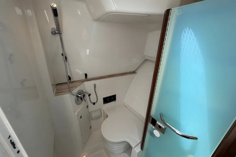 Slide: The Image of 2019 Pursuit DC 365 Dual Console boat bathroom with shower and frosted glass door. - 63