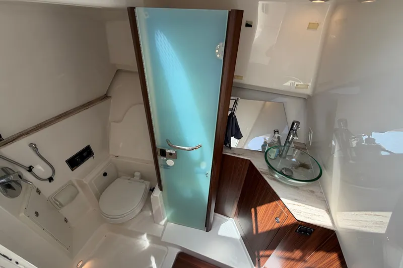 Slide: The Image of 2019 Pursuit DC 365 Dual Console boat bathroom with modern fixtures and glass sink. - 62