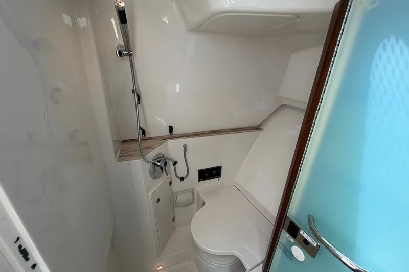 Slide: The Image of 2019 Pursuit DC 365 Dual Console boat bathroom with shower and toilet. - 64