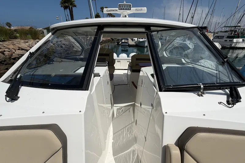 Slide: The Image of 2019 Pursuit DC 365 Dual Console boat docked in a marina, showcasing sleek design and spacious interior. - 65