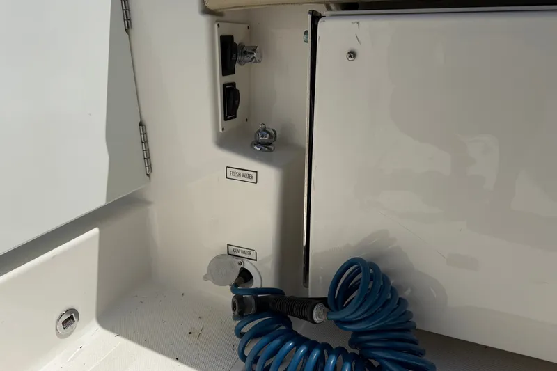 Slide: The Image of 2019 Pursuit DC 365 Dual Console boat water connections with blue hose. - 72
