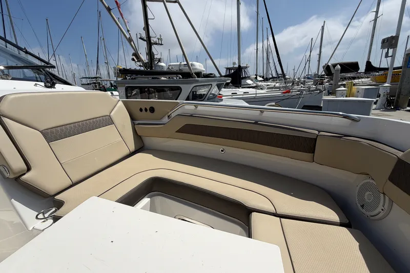 Slide: The Image of 2019 Pursuit DC 365 Dual Console boat interior with beige seating at marina. - 69