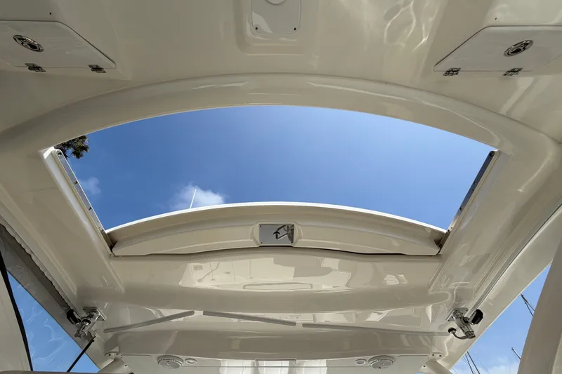 Slide: The Image of 2019 Pursuit DC 365 Dual Console boat roof with open sunroof under clear blue sky. - 45