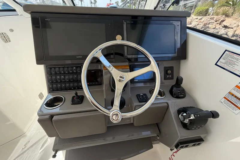 Slide: The Image of 2019 Pursuit DC 365 Dual Console helm with steering wheel, dual displays, and control panel. - 26