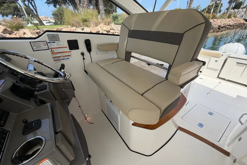 Slide: The Image of 2019 Pursuit DC 365 Dual Console interior with helm seat and steering wheel. - 32
