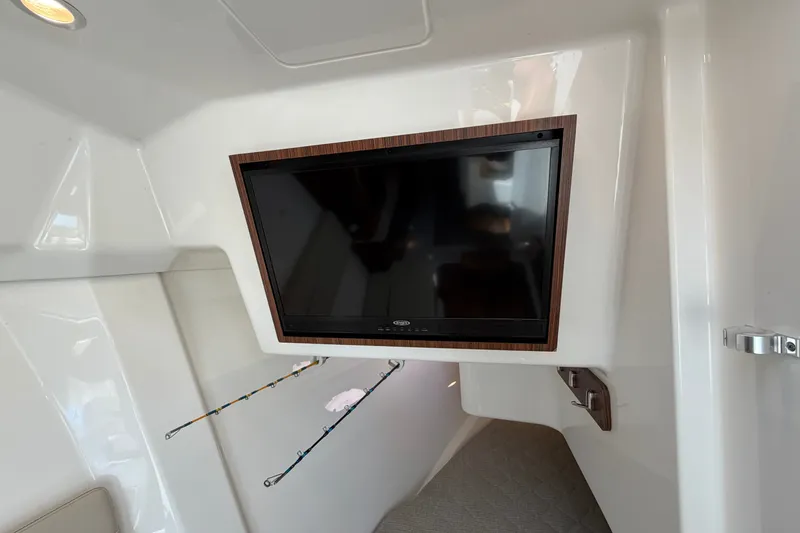Slide: The Image of 2019 Pursuit DC 365 Dual Console interior with mounted TV and fishing rod holders. - 53