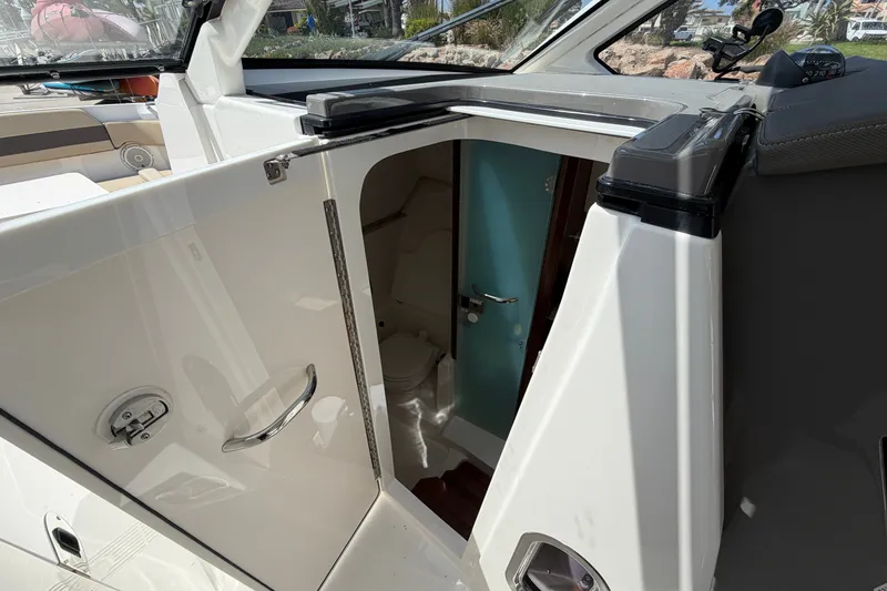 Slide: The Image of 2019 Pursuit DC 365 Dual Console boat interior with open cabin door. - 61