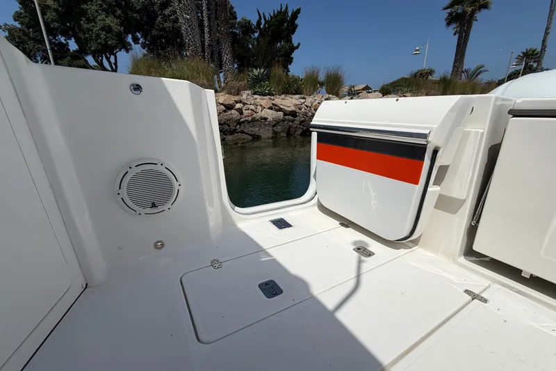 Slide: The Image of 2019 Pursuit DC 365 Dual Console boat interior with open hatch, dockside view. - 16