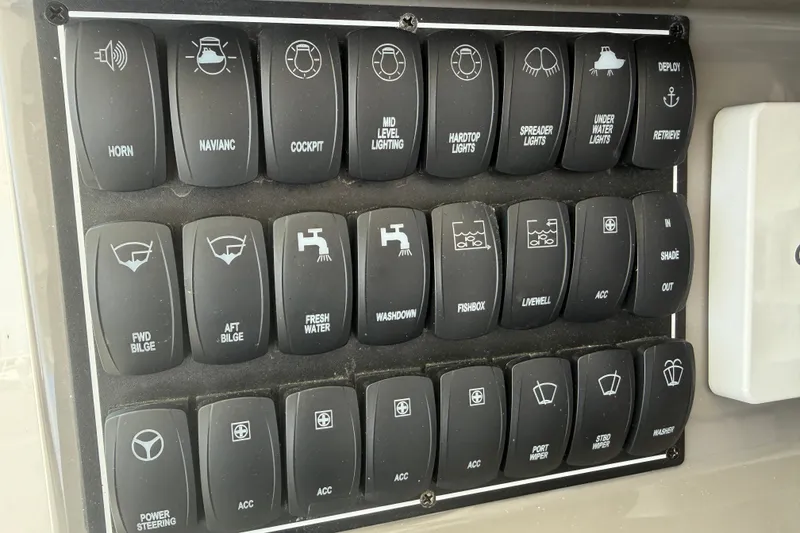 Slide: The Image of Control panel of a 2019 Pursuit DC 365 Dual Console boat with labeled switches. - 30