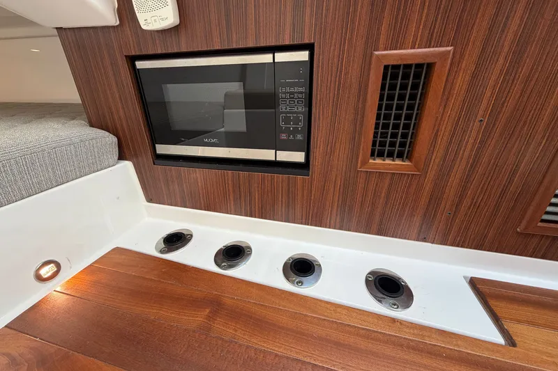 Slide: The Image of 2019 Pursuit DC 365 Dual Console interior with microwave and wood paneling. - 54