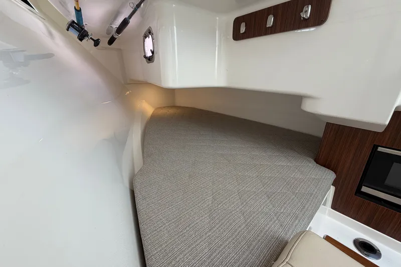 Slide: The Image of Interior cabin of 2019 Pursuit DC 365 Dual Console boat, featuring a cozy sleeping area. - 55