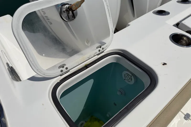 Slide: The Image of Open storage compartment on a 2019 Pursuit DC 365 Dual Console boat. - 18