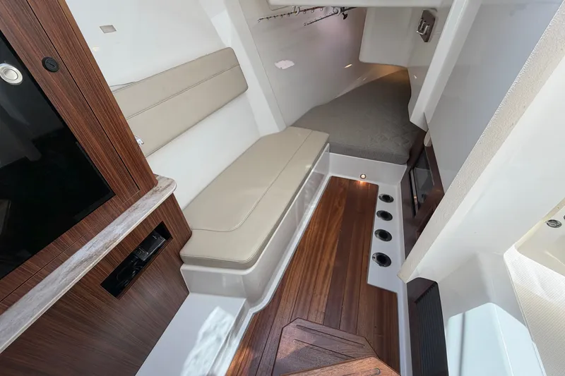 Slide: The Image of 2019 Pursuit DC 365 Dual Console cabin interior with wood accents and seating. - 50