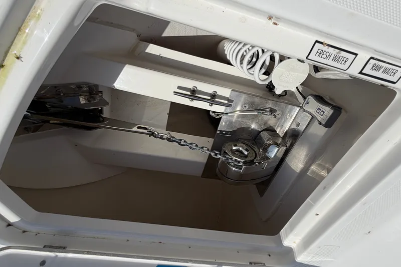 Slide: The Image of Anchor compartment of 2019 Pursuit DC 365 Dual Console boat with water access controls. - 77