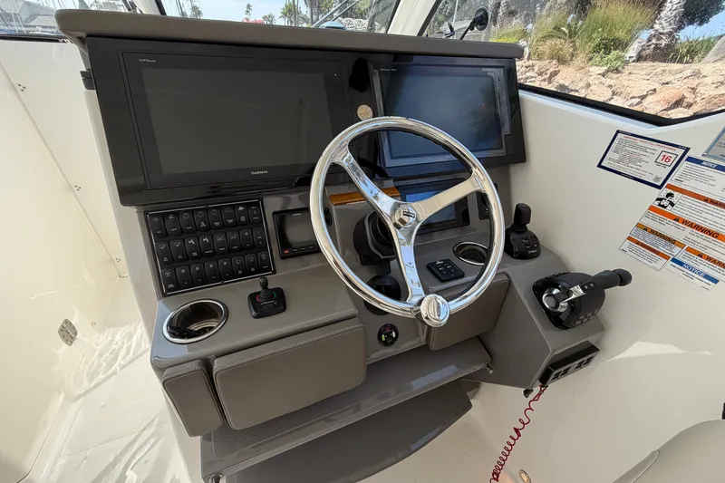 Slide: The Image of Helm of 2019 Pursuit DC 365 Dual Console with steering wheel and navigation screens. - 27
