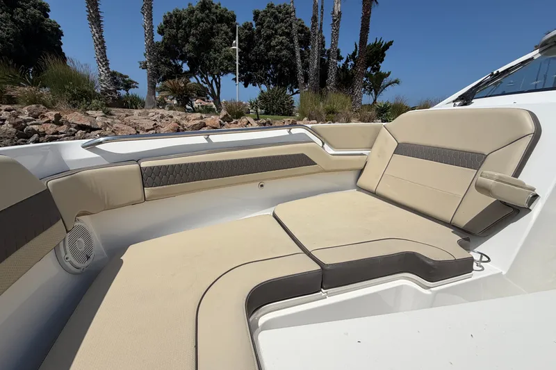 Slide: The Image of 2019 Pursuit DC 365 Dual Console boat interior with beige seating and scenic background. - 71