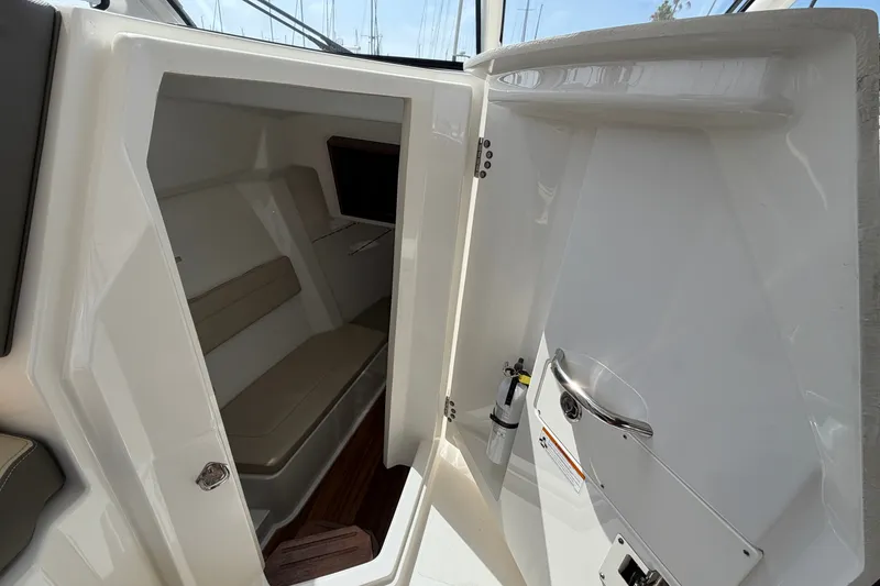 Slide: The Image of Interior cabin of a 2019 Pursuit DC 365 Dual Console boat, featuring seating and storage. - 47