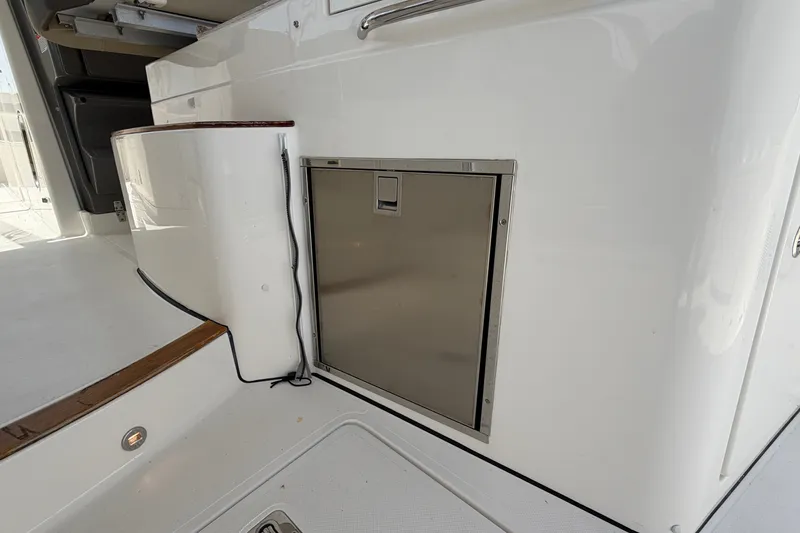 Slide: The Image of 2019 Pursuit DC 365 Dual Console boat interior with stainless steel storage compartment. - 20
