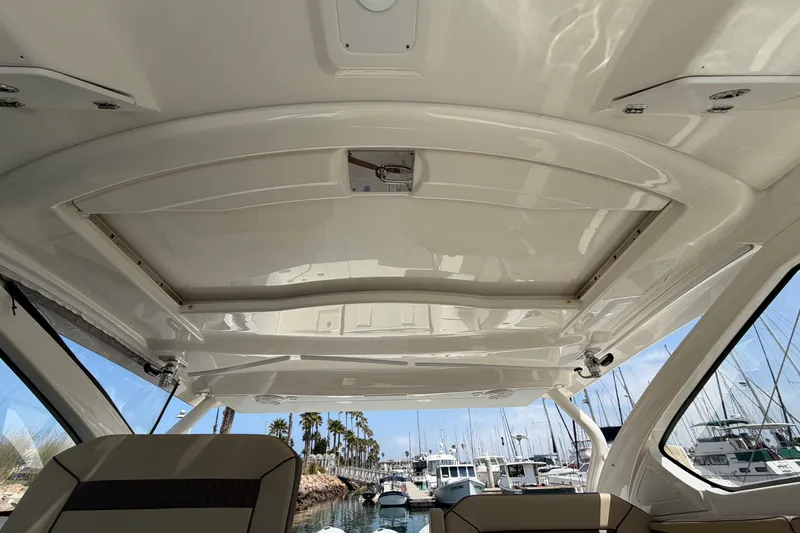 Slide: The Image of Interior view of 2019 Pursuit DC 365 Dual Console boat with marina background. - 44