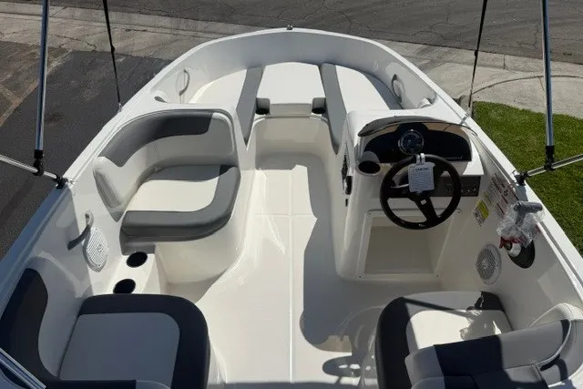Slide: The Image of 2027 Bayliner Element E16 boat interior with seating and steering wheel, docked on a sunny day. - 13