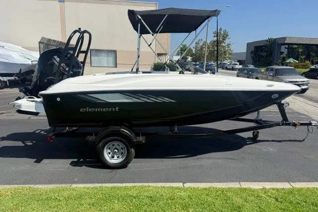 The Image of 2027 Bayliner Element E16 boat on trailer, parked outdoors with canopy. - 0