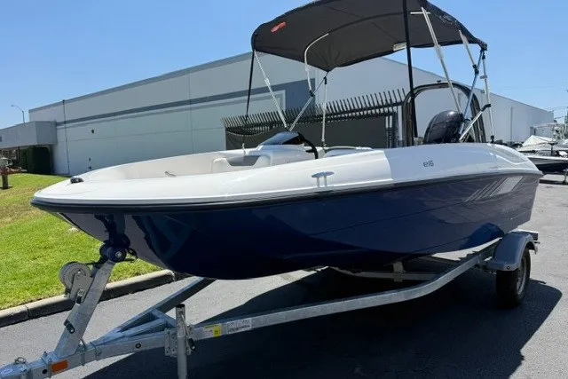 Slide: The Image of 2027 Bayliner Element E16 boat on trailer, blue hull, parked outdoors. - 5