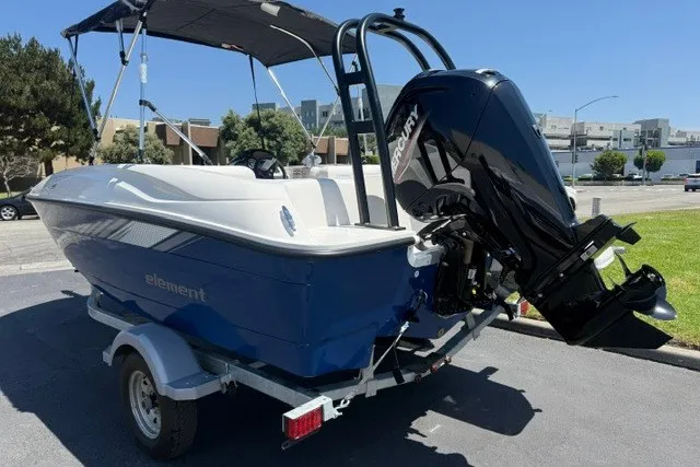 Slide: The Image of 2027 Bayliner Element E16 boat with Mercury engine on trailer, parked outdoors. - 12