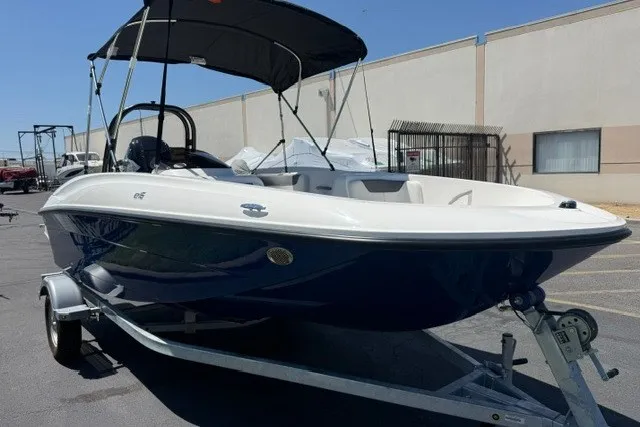 Slide: The Image of 2027 Bayliner Element E16 boat on trailer, parked outdoors with canopy. - 15