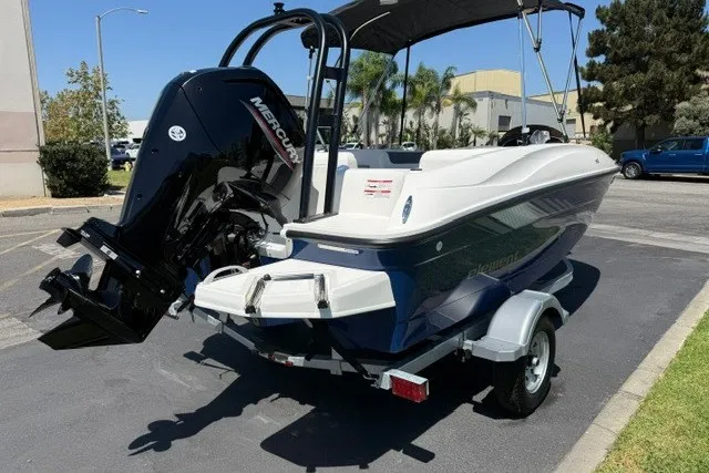Slide: The Image of 2027 Bayliner Element E16 boat with Mercury engine on a trailer in a parking lot. - 16