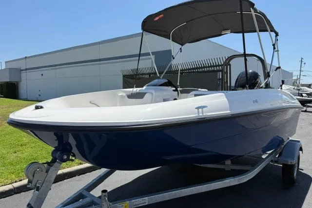 Slide: The Image of 2027 Bayliner Element E16 boat on trailer with canopy, parked outdoors. - 18