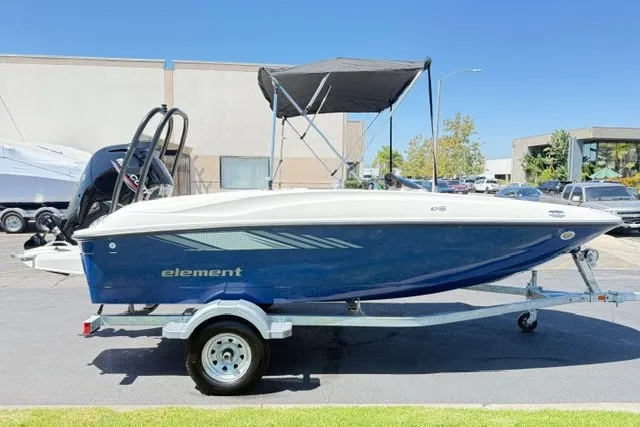The Image of 2027 Bayliner Element E16 boat on trailer, blue hull, parked outdoors under clear sky. - 0