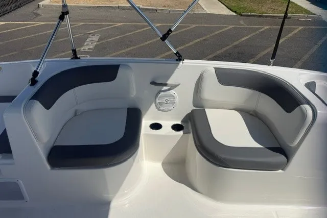 Slide: The Image of 2027 Bayliner Element E16 boat interior with gray and white seating, cup holders, and speaker. - 3