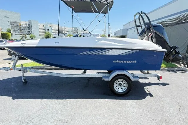 Slide: The Image of 2027 Bayliner Element E16 boat on trailer, parked outdoors in a sunny setting. - 1