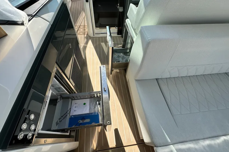 Slide: The Image of Interior of 2027 Saxdor 400 GTC boat with open storage compartments and cushioned seating. - 25