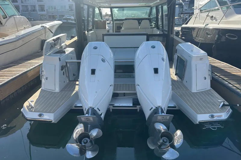 Slide: The Image of 2027 Saxdor 400 GTC boat with dual outboard engines docked at marina. - 34