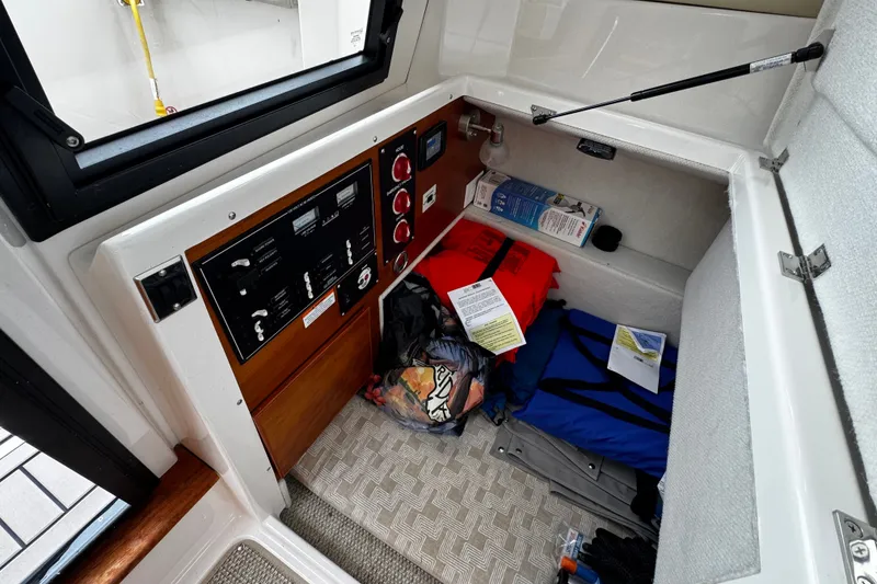 Slide: The Image of 2024 Cutwater C-248 Coupe interior storage with safety equipment and control panel. - 11