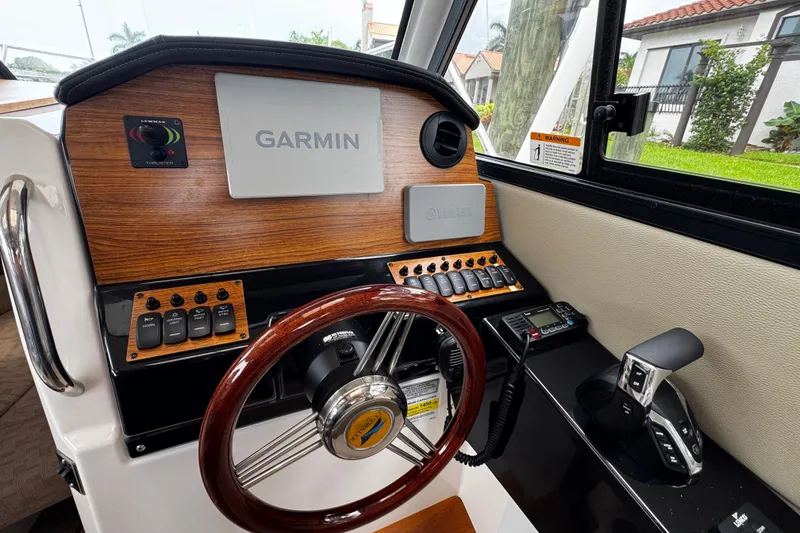 Slide: The Image of 2024 Cutwater C-248 Coupe helm with Garmin navigation, wooden accents, and modern controls. - 7