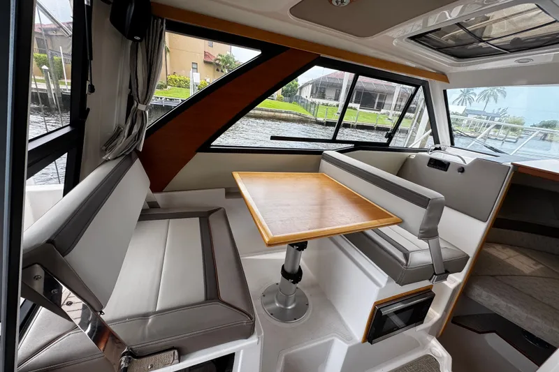 Slide: The Image of Interior of 2024 Cutwater C-248 Coupe featuring a cozy dining area with a wooden table. - 4
