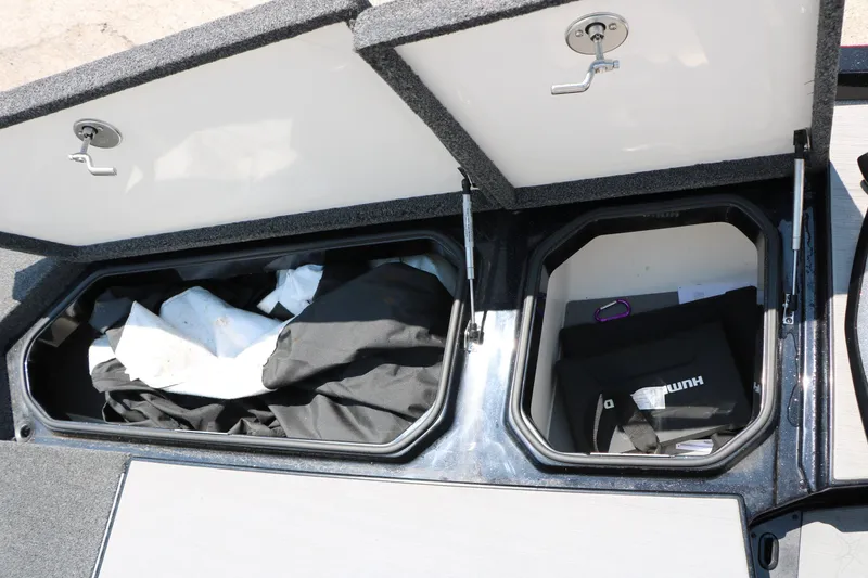 Slide: The Image of Open storage compartments on a 2022 Vexus VX21 boat, containing gear and equipment. - 57