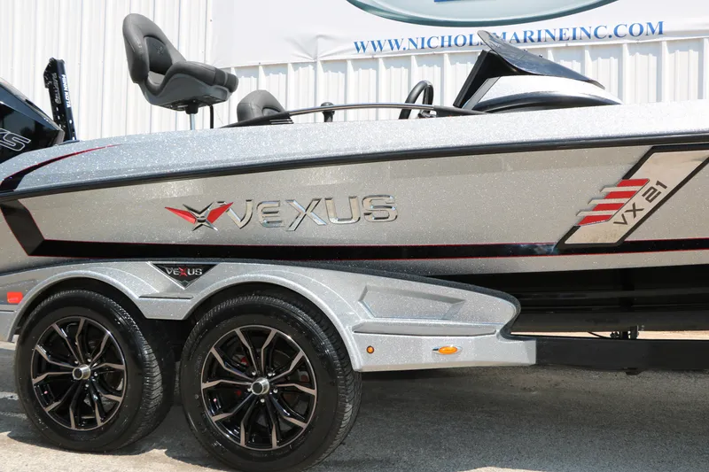 Slide: The Image of 2022 Vexus VX21 boat with sleek design and dual axle trailer. - 24