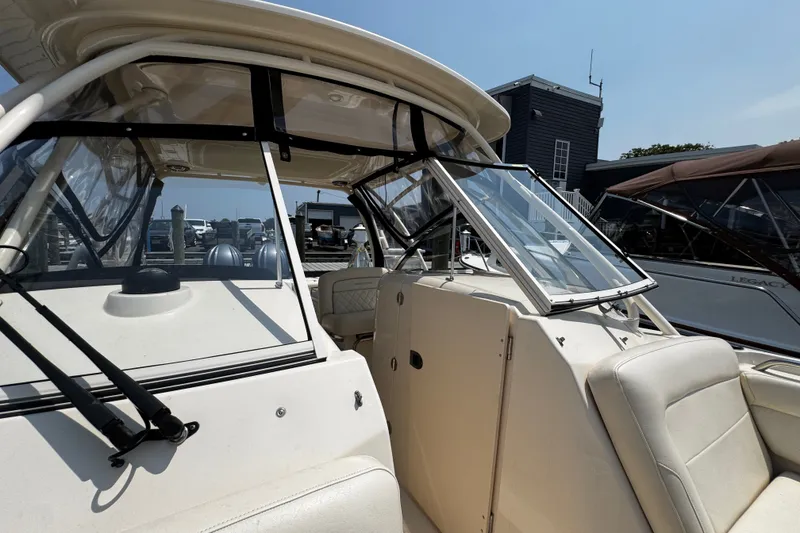 Slide: The Image of 2022 Grady-White Freedom 285 boat interior with seating and windshield, docked at marina. - 15