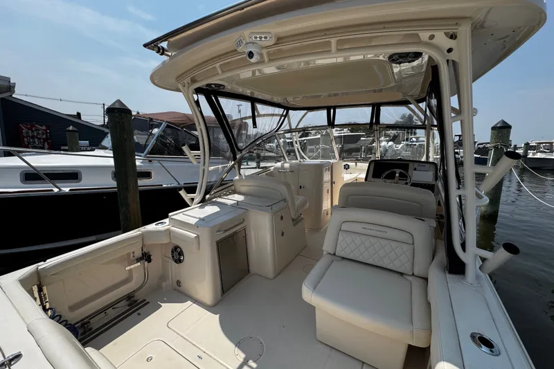 Slide: The Image of 2022 Grady-White Freedom 285 boat interior at marina, featuring spacious seating and helm. - 42