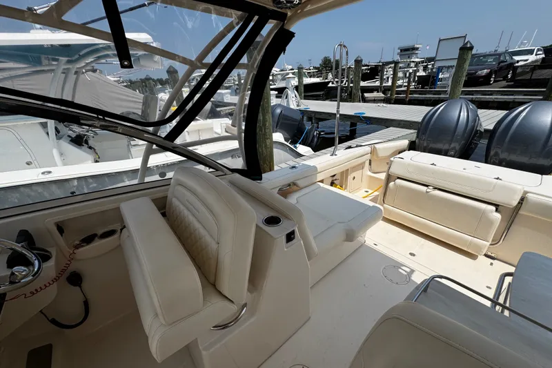 Slide: The Image of 2022 Grady-White Freedom 285 boat interior with seating and dual outboard motors at dock. - 22