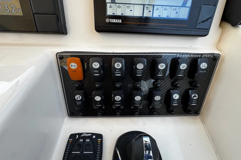 Slide: The Image of Control panel of 2022 Grady-White Freedom 285 boat with various switches and Yamaha display. - 31