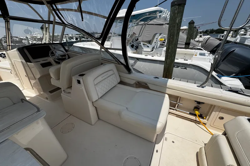 Slide: The Image of 2022 Grady-White Freedom 285 boat interior with seating and helm, docked at marina. - 24