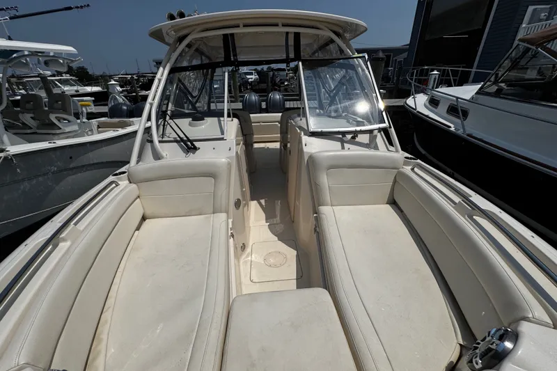 Slide: The Image of 2022 Grady-White Freedom 285 boat interior with seating and windshield, docked at marina. - 11