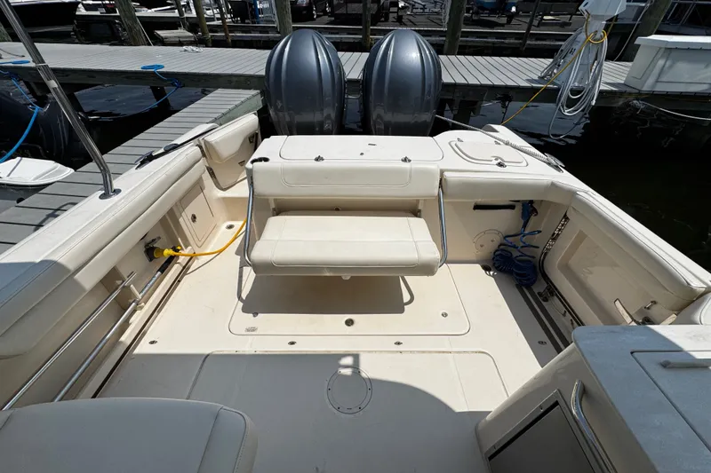 Slide: The Image of 2022 Grady-White Freedom 285 boat interior with seating and dual outboard motors at dock. - 39